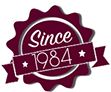 maroon star shaped badge reading since 1984
