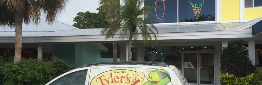 tables and chairs with cartoon surfing turtle mural on wall