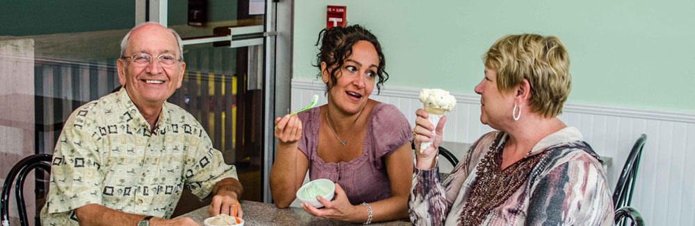 three people eating ice cream from bowl and waffle cone